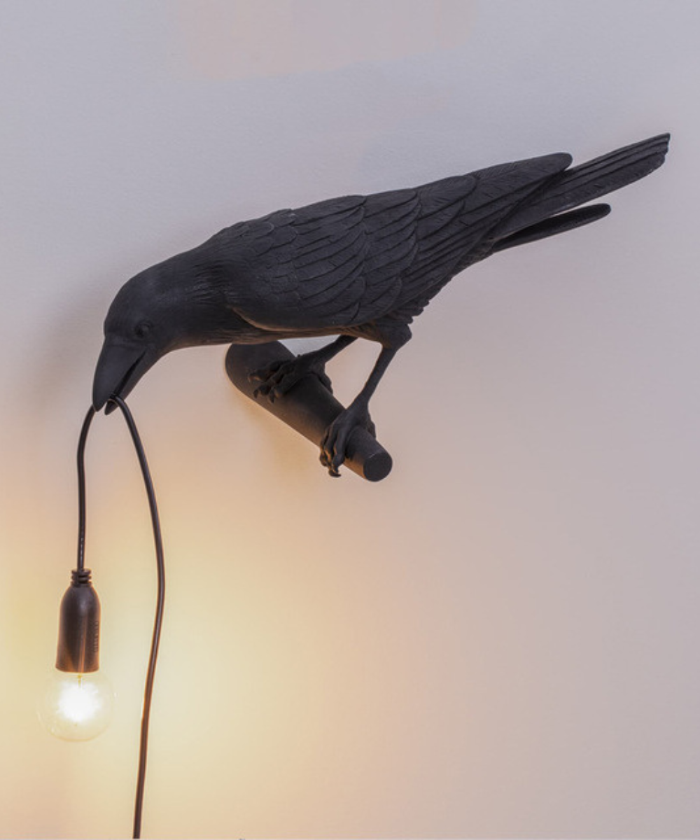 Stolní lampa Raven — pryskyřicová soška s žárovkou v zobáku, černá a bílá