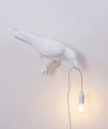 Stolní lampa Raven — pryskyřicová soška s žárovkou v zobáku, černá a bílá