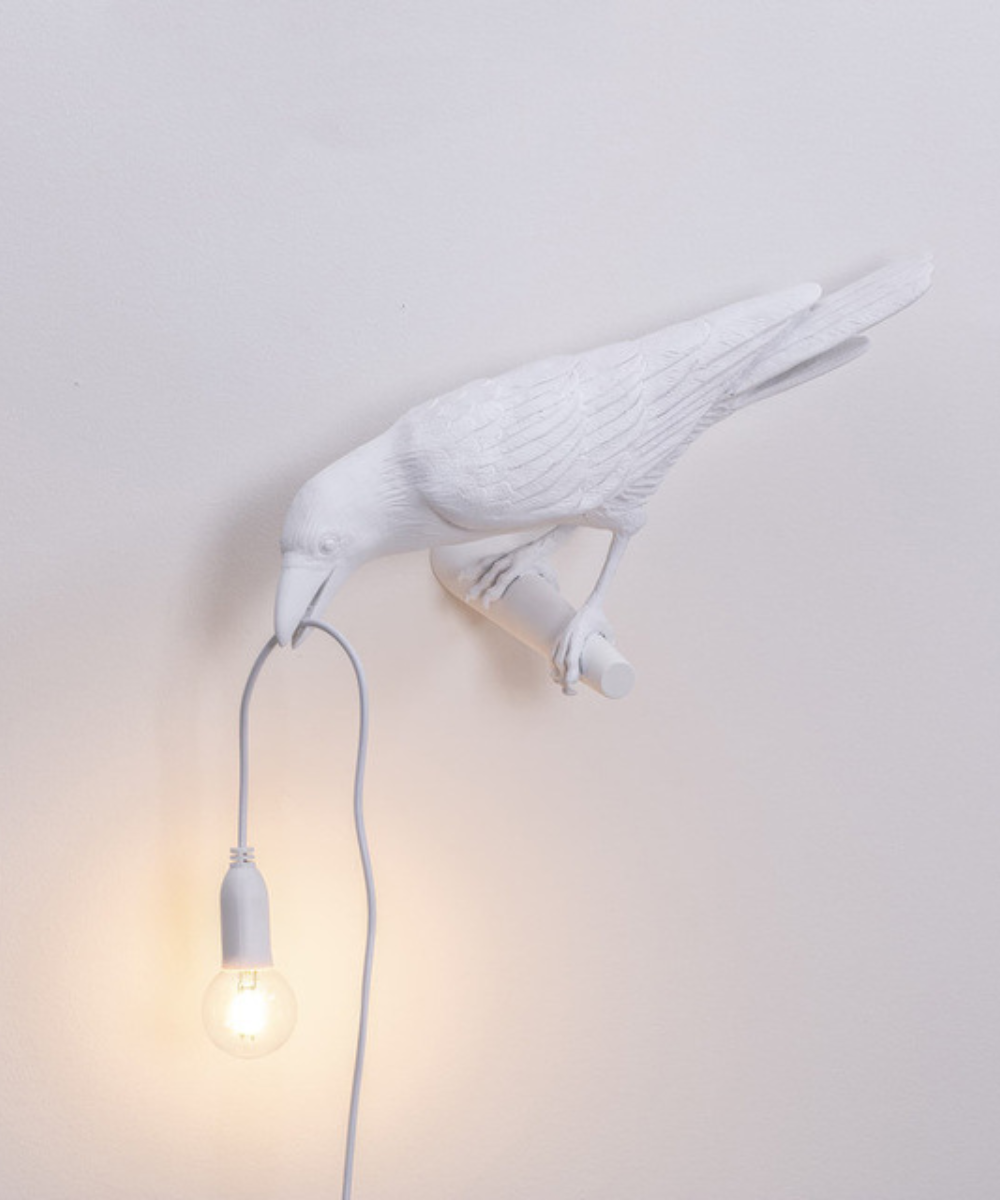 Stolní lampa Raven — pryskyřicová soška s žárovkou v zobáku, černá a bílá