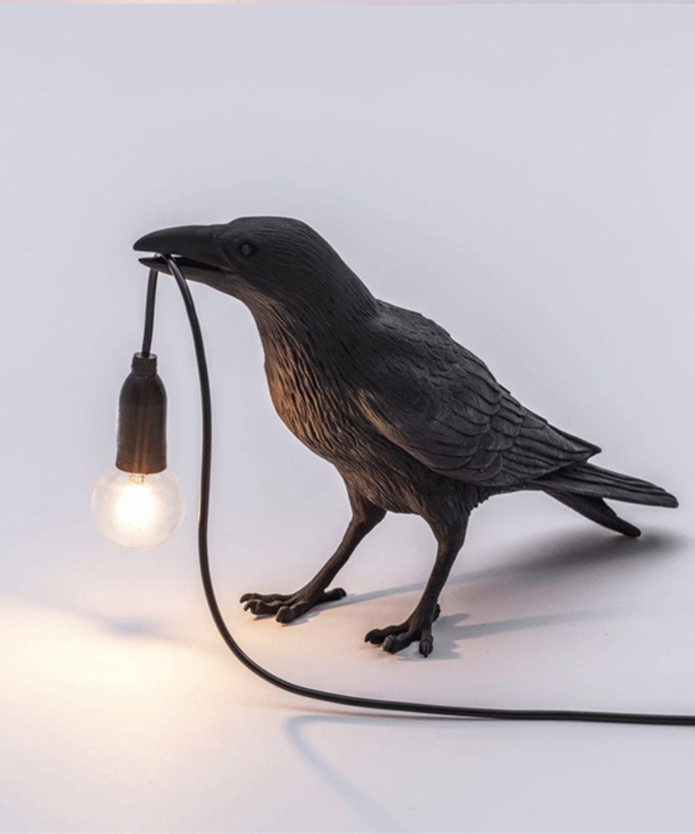 Stolní lampa Raven — pryskyřicová soška s žárovkou v zobáku, černá a bílá