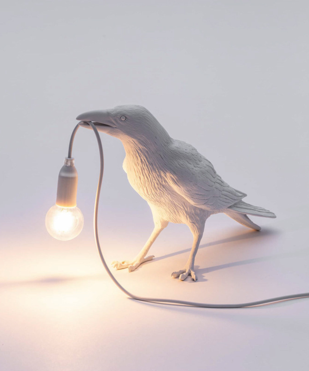 Stolní lampa Raven — pryskyřicová soška s žárovkou v zobáku, černá a bílá